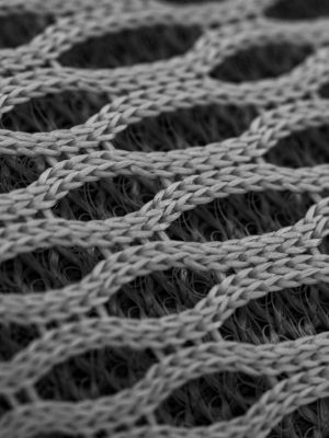 A detailed close-up of a grey knit nylon fabric creating an abstract geometric pattern, perfect for texture and design concepts.