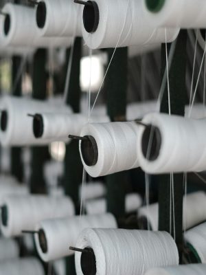Close-up of white sewing threads on spools, showcasing textile production in Vietnam.