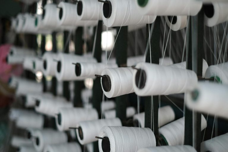 Close-up of white sewing threads on spools, showcasing textile production in Vietnam.